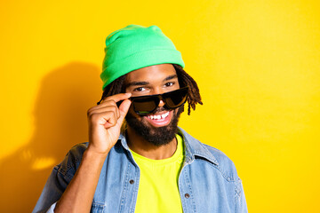 Photo of young handsome cheerful good mood smiling african man in sunglasses isolated on yellow color background