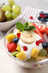 Delicious fruit salad with yogurt on light table