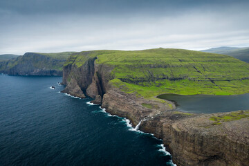 Coast, waterfall and cliffs at Tr&aelig;lan&iacute;pa on the island of Vagar, with Lake Leitisvatn from above.