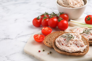 Sandwiches with delicious lard spread and vegetables on white marble table