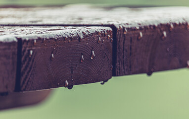 Tropfen auf einem Gartentisch aus Holz an einem warmen Sommerregen - Regnerischer Sommertag im...