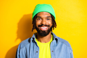 Photo of attractive happy dark skin man wear green hat hipster isolated on shine yellow color background