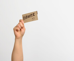 female hand holding a piece of paper with the inscription donate