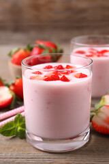 Yummy drink with strawberries on wooden table