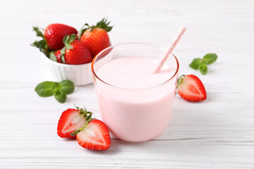 Delicious drink with strawberries on white wooden table