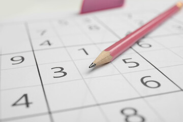 Sudoku puzzle grid and pencil, closeup view