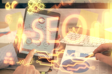 Multi exposure of man's hands holding and using a digital device and seo drawing. search...