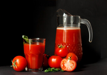 Fresh tomato juice in a glass with tomatoes  on a dark background. Vegetable tomato drink for a healthy diet on  background