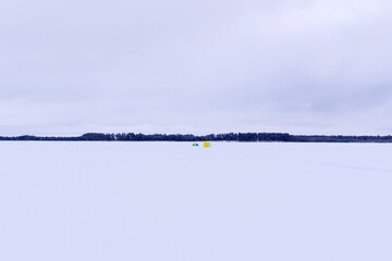 winter tent on the lake for fishing. winter sports space for copying text. fishing equipment