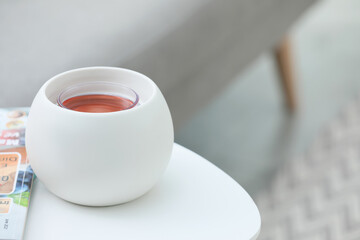 Wax air freshener and magazine on white table indoors, space for text. Interior elements
