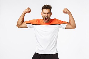 Power, sport and fitness concept. Handsome strong and powerful aggressive man brag perfect shape, shouting, encourage gym visitors train hard, showing muscles, standing white background