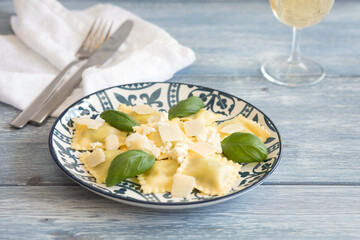Cooked ravioli with ricotta and basil, on a light background 