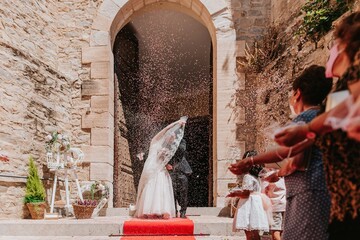 Novios saliendo de la iglesia. Gente tirando arroz en boda. Momento del arroz en una boda. Recién...