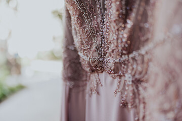 Detalle de vestido de novia rosa. Preparativos el día de la boda en casa de la novia.