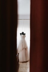 Vestido de novia blanco en habitación. Vestido en maniquí. Preparativos el día de la boda en casa de la novia.