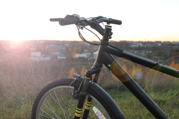 Fototapeta na wymiar Bike on the background of the city and sunset on a sunny day