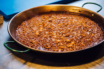 Cooking paella in large pot - Spanish food