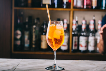 Syringe Aperol with orange and mint in a beautiful glass glass on the bar