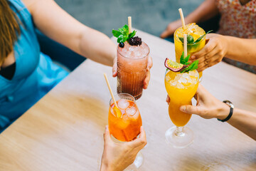 Group of young friends clinking glasses with glasses celebrating in the afternoon on the terrace