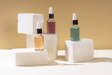 Glass bottles with a pipette of aroma oil, liquid serum or hyaluronic acid in a modern studio.