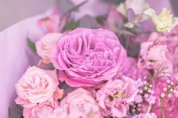 Fototapeta na wymiar A lush bouquet of light pink, purple cute delicate small roses of different sizes, flowers. Big rose in the middle. Close-up. Macro