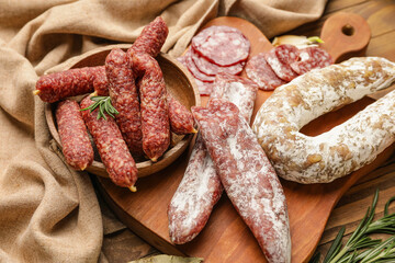 Board with different sausages on wooden background