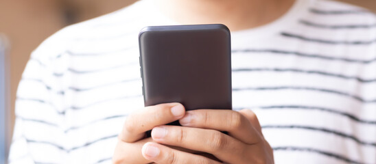 Hand holding and using smartphone.