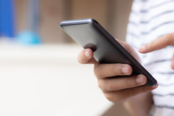 Hand holding and using smartphone.