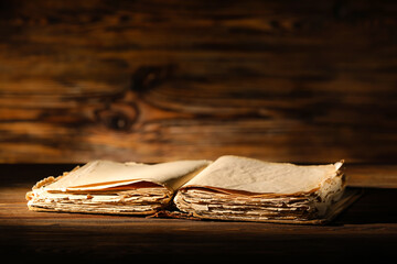Open old book on dark wooden background