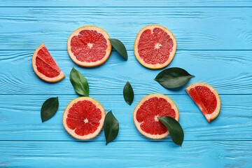 Fresh sliced grapefruit on color wooden background