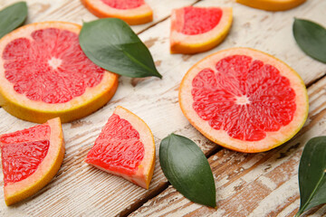 Fresh sliced grapefruit on light wooden background