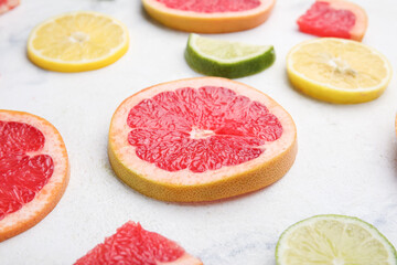 Fototapeta na wymiar Fresh sliced citrus fruits on light background