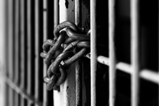 chain around metal bars, black and white - Powered by Adobe