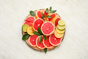 Plate with fresh sliced citrus fruits on light background