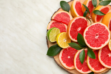 Plate with fresh sliced citrus fruits on light background