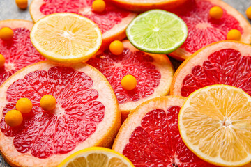Fototapeta na wymiar Vitamin C pills and citrus fruits slices, closeup