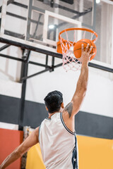 Sportman throwing a ball into the basket