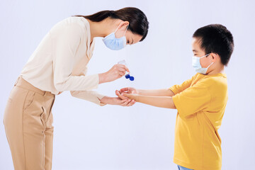 The mother taught the little boy to use hand sanitizer