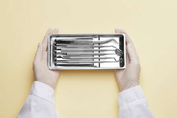 Dentist with instruments on color background