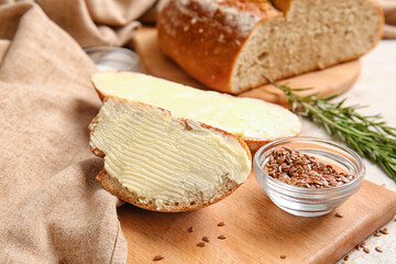 Slices of fresh bread with butter, flax seeds and rosemary on light background, closeup