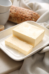 Fresh butter and bread on table, closeup