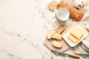 Composition with fresh butter and bread on light background