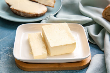 Box with fresh butter on color background, closeup