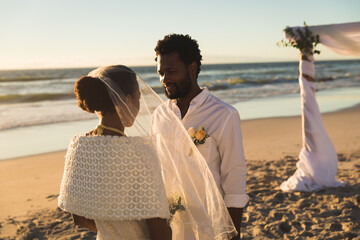 African american couple in love getting married on beach looking to each other
