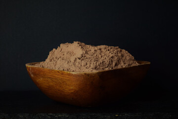 Bowl full of cocoa powder. Dark food. Close up, copy space.