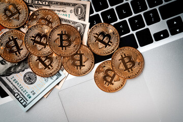 Business top view design concept of bitcoin with USD Dollar paper currency on laptop.
