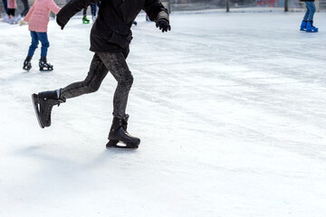 A man skates on an ice rink in winter.