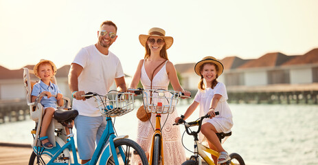 Joyful family riding bicycles along wooden promenade