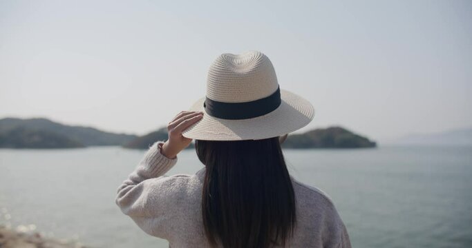 Woman wear straw hat and look at the sea