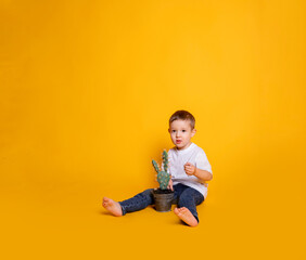 child in jeans and a white t-shirt on a yellow background